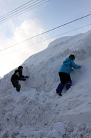 雪の壁を登る子供達 